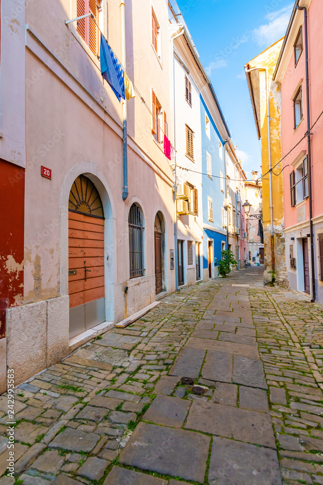 Old and narrow streets in Piran city, Slovenia. Ancient medieval streets in town center of famous European city, near the adriatic sea. Old houses with wooden windows and doors, magical atmosphere.