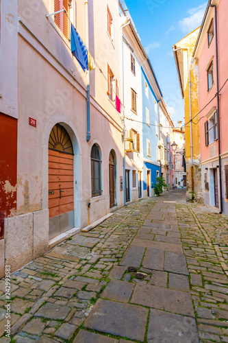 Old and narrow streets in Piran city, Slovenia. Ancient medieval streets in town center of famous European city, near the adriatic sea. Old houses with wooden windows and doors, magical atmosphere.