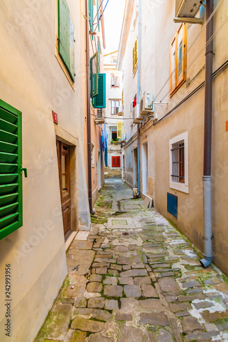 Fototapeta Naklejka Na Ścianę i Meble -  Old and narrow streets in Piran city, Slovenia. Ancient medieval streets in town center of famous European city, near the adriatic sea. Old houses with wooden windows and doors, magical atmosphere.