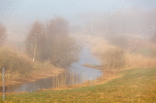 River flowing through a misty landscape