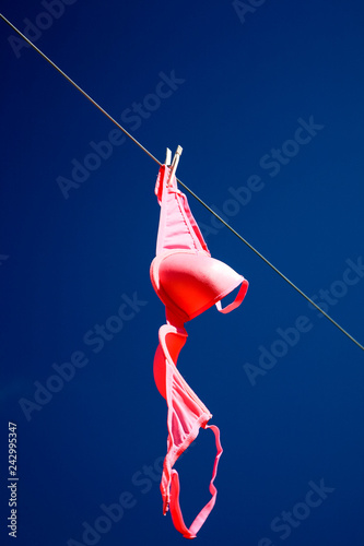 Pink bra drying on a washing line
