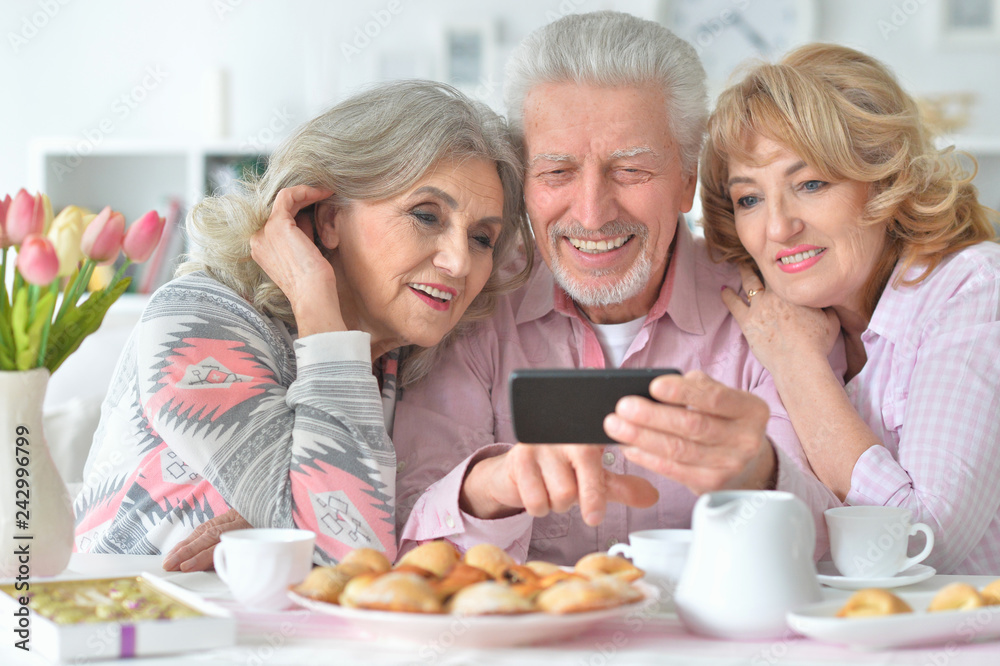 Portrait of happy senior people with smartphone drinking tea Portrait of happy senior people with smartphone drinking tea