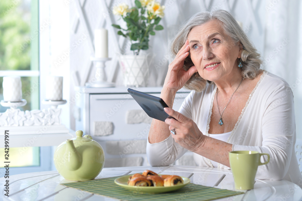 Portrait of cute old woman with tablet at home Portrait of cute old woman with tablet at home