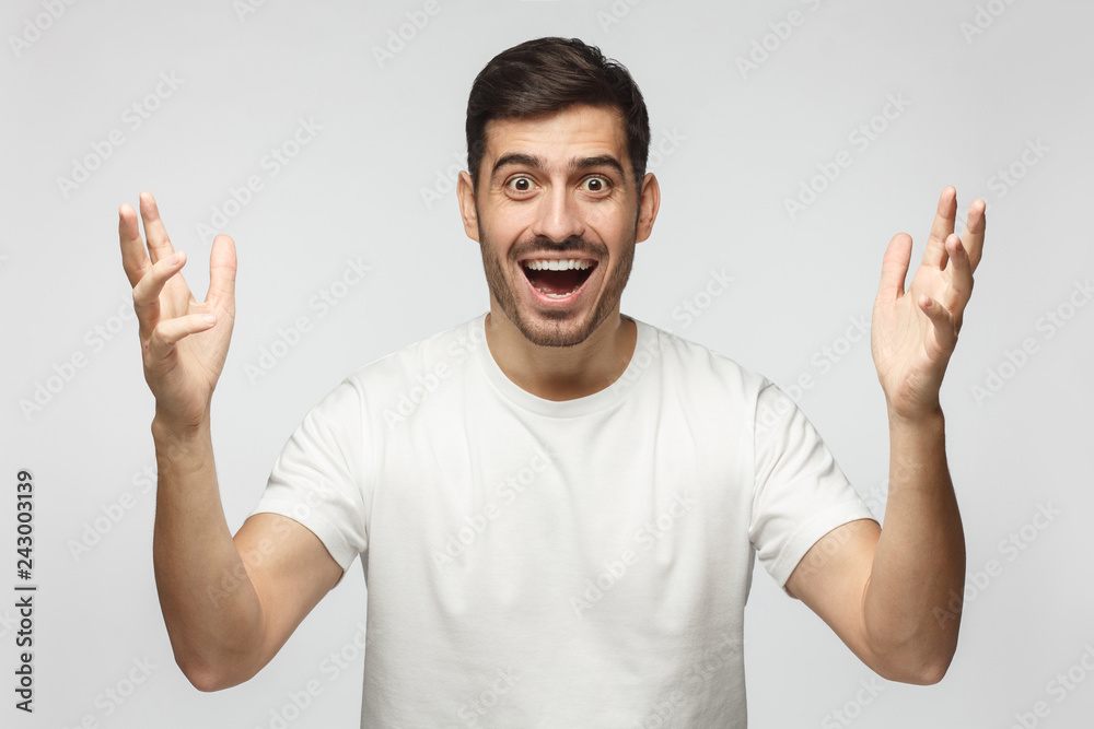 Young happy crazy man showing big size gesture with hands, emphasizing great amount of something Young happy crazy man showing big size gesture with hands, emphasizing great amount of something