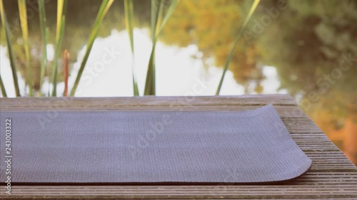 Unrolling yoga mat on wooden pier