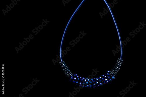 Blue pendant with crystals on black background