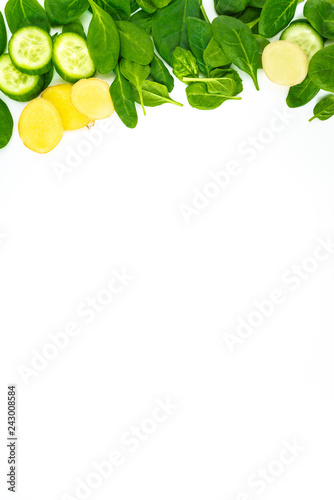 Fresh green leaves spinach, slices of cucumber and ginger isolated on a white background. Vegetables at border of image with copy space for text. Healthy and detox concept
