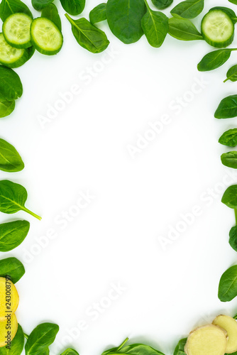 Fresh green leaves spinach, slices of cucumber and ginger isolated on a white background. Vegetables at border of image with copy space for text. Healthy and detox concept
