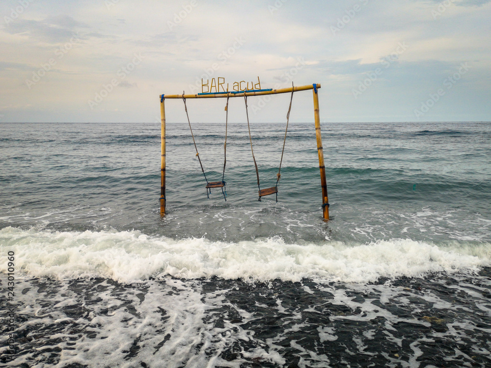 Double swing in the ocean at the beach in Amed village in Bali Indonesia Double swing in the ocean at the beach in Amed village in Bali Indonesia