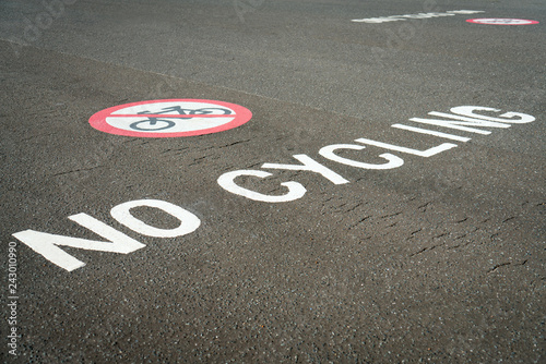No cycling sign on pavement footpath in public area. A painted no cycling sign on the sidewalk in UK. © wittayayut