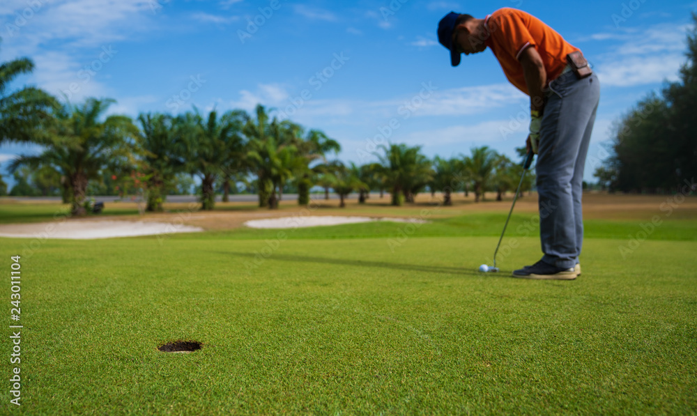 Fototapeta premium Golfer hitting golf shot with club on course vintage color tone, Man playing golf on a golf course in the sun, Golfers hit sweeping golf course in the summer