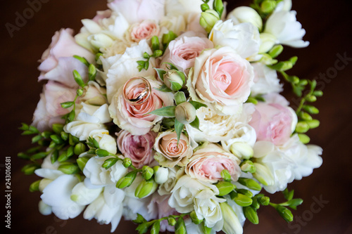 A pair of wedding gold rings on a bouquet of colorful flowers  close up shot