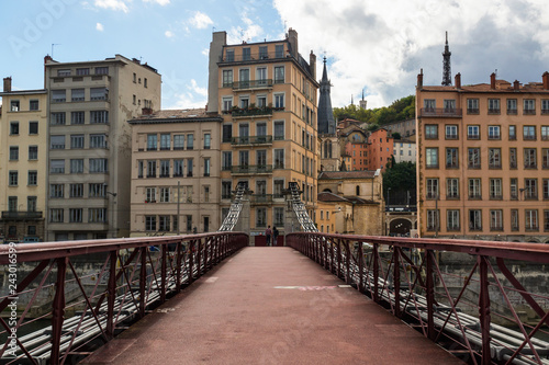 Pedestrian bridge Saint-Georges crossing the Saone river with the couple and old french Lyon city on the background.