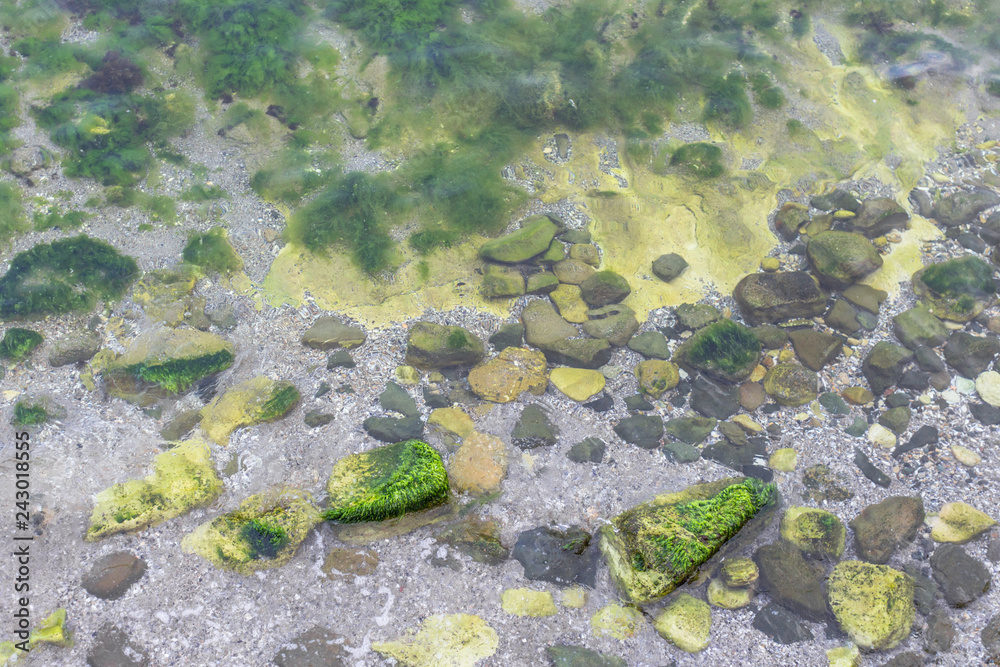 Multi-colored sea stones. Large stones in the sea or ocean. Seascape. Stone mound. The Black Sea coast in Nessebar. Nature of Bulgaria. Euro-trip. Cobblestones in the water.