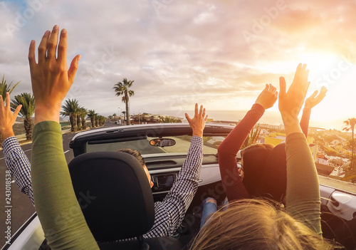 Valokuva Happy friends having fun in convertible car at sunset in vacation - Young people