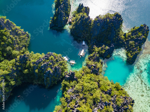 Aerial view to tropical Twin lagoon with azure water and traditional sailing boats, Coron island. Palawan, Philippines.