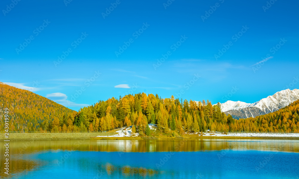 autumn landscape in Ultental ( Ultimo Valley) with a trees in autumn colors.the little Lake Fontana Bianca at almost 1,900 m a.s.l.,Dolomites, South Tyrol, province of Bolzano, Italy, Europe.