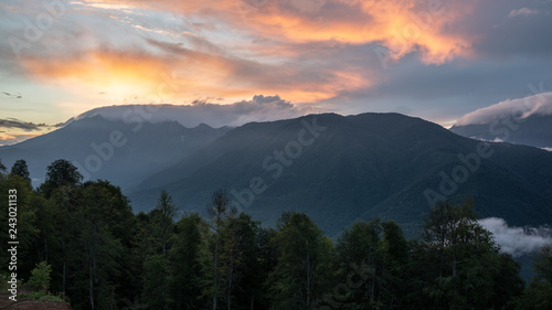 Pink sunset over the Valley, surrounded by mountains and forest