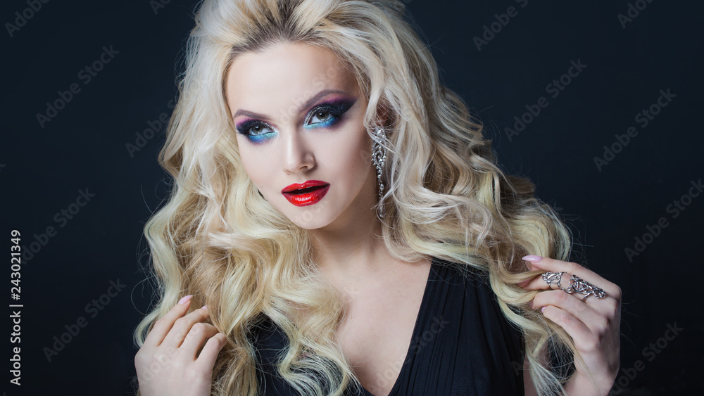Fototapeta premium Portrait of a young luxurious blonde with long curls.
