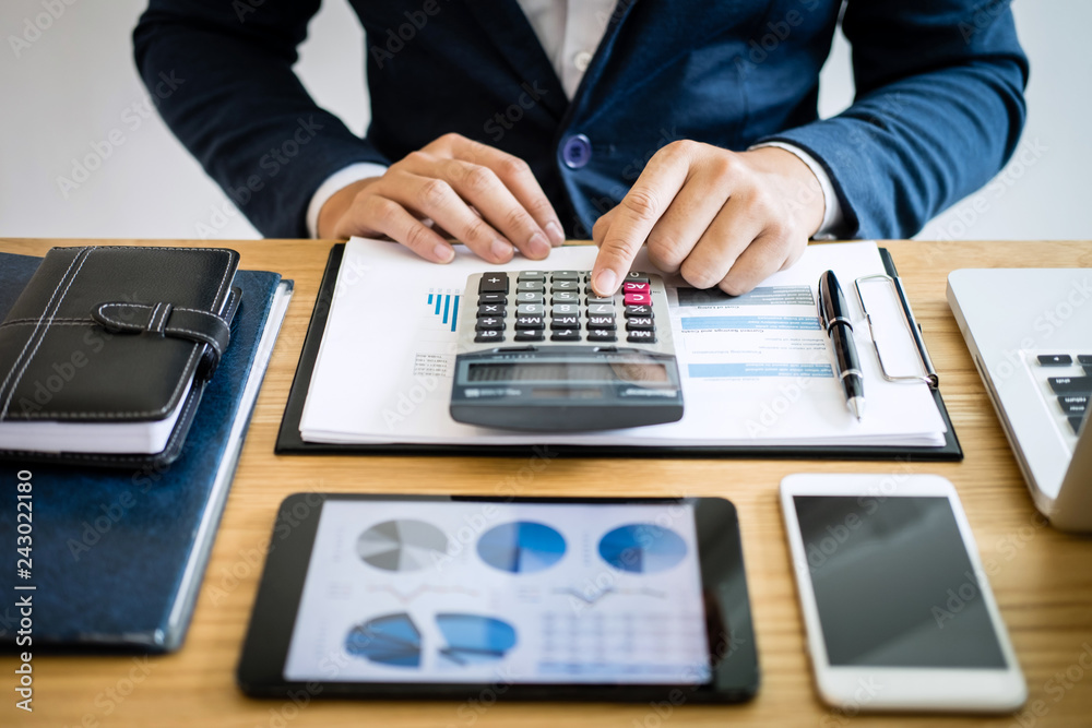 Businessman hands using text information on digital tablet to analyze financial statistical chart data and calculate cost of investment project Businessman hands using text information on digital tablet to analyze financial statistical chart data and calculate cost of investment project