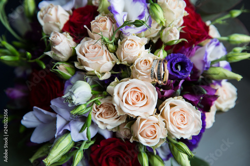 A pair of wedding gold rings on a bouquet of colorful flowers  close up shot