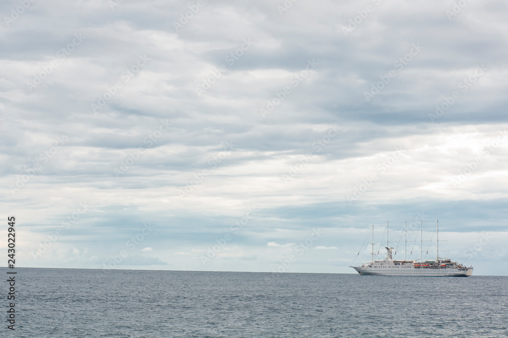 Cruising ship on empty sea with beautiful dramatic clouds