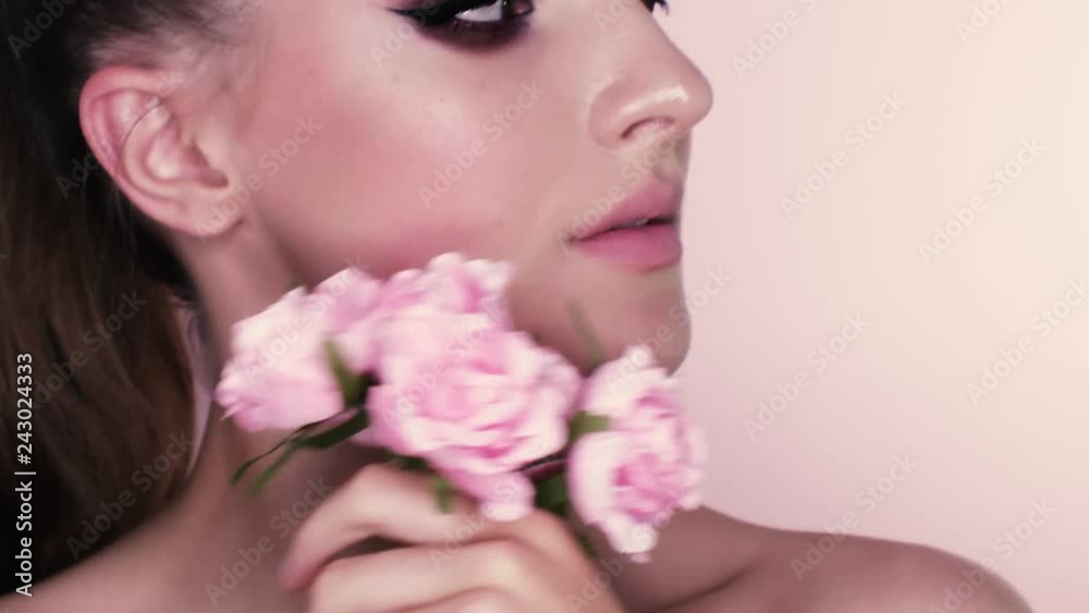beauty portrait of a beautiful girl with makeup and flowers. closeup shot in studio on a pink background beauty portrait of a beautiful girl with makeup and flowers. closeup shot in studio on a pink background