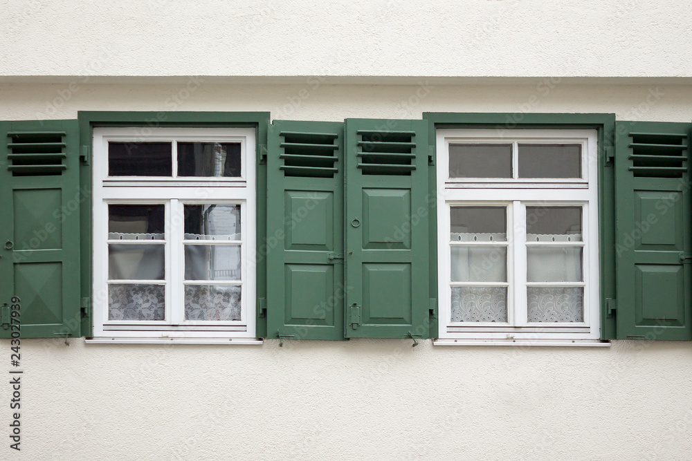 Old ancient wooden window with blinds or shutters. Scenic original and colorful view of antique windows in old city Sindelfingen, Germany. Isolated on wall. No people. Front view. Old fashioned style. Old ancient wooden window with blinds or shutters. Scenic original and colorful view of antique windows in old city Sindelfingen, Germany. Isolated on wall. No people. Front view. Old fashioned style.