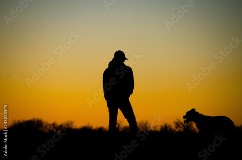 silhouette of man in sunset with dog