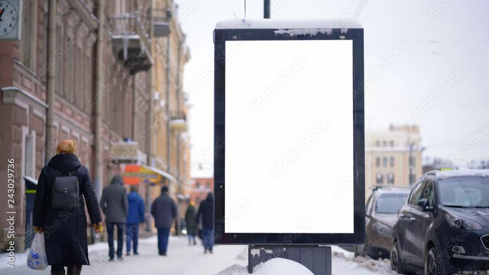 Vertical mock-up of city poster winter city with thick edges, blank white billboard in urban settings, empty street information placeholder. People walking down the street. Vertical mock-up of city poster winter city with thick edges, blank white billboard in urban settings, empty street information placeholder. People walking down the street.