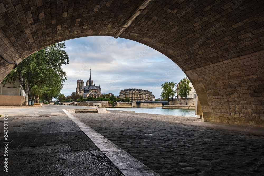 Bank of Seine river with Notre Dame de Paris cathedral view from under the bridge, Paris, France