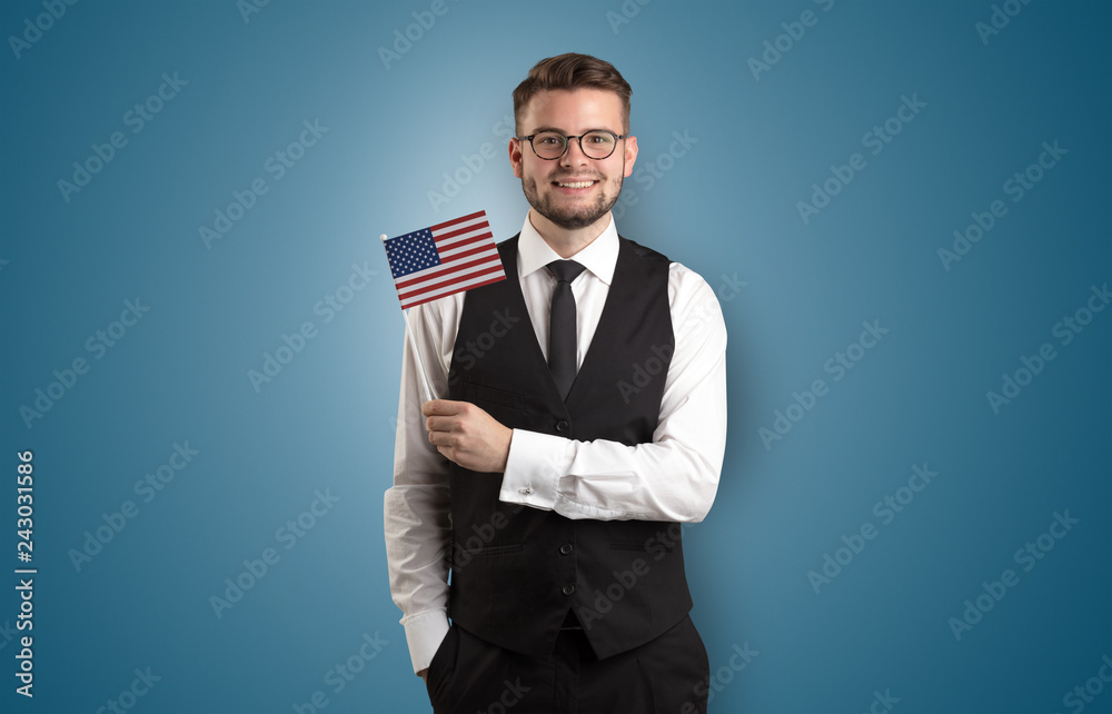 Cheerful student standing in front of wall with national flag on his hand
Cheerful student standing in front of wall with national flag on his hand