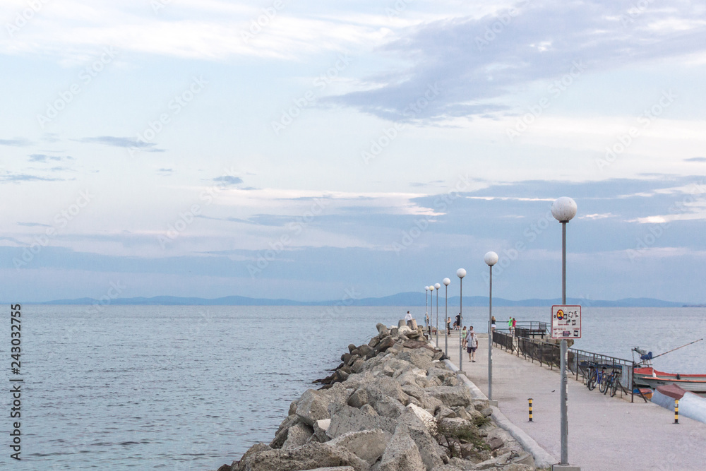 Seaside pier. Pier at the seaside resort. Summer holiday on the coast of Bulgaria. Sea air. Euro-trip. The promenade on the Black Sea. Ocean view.