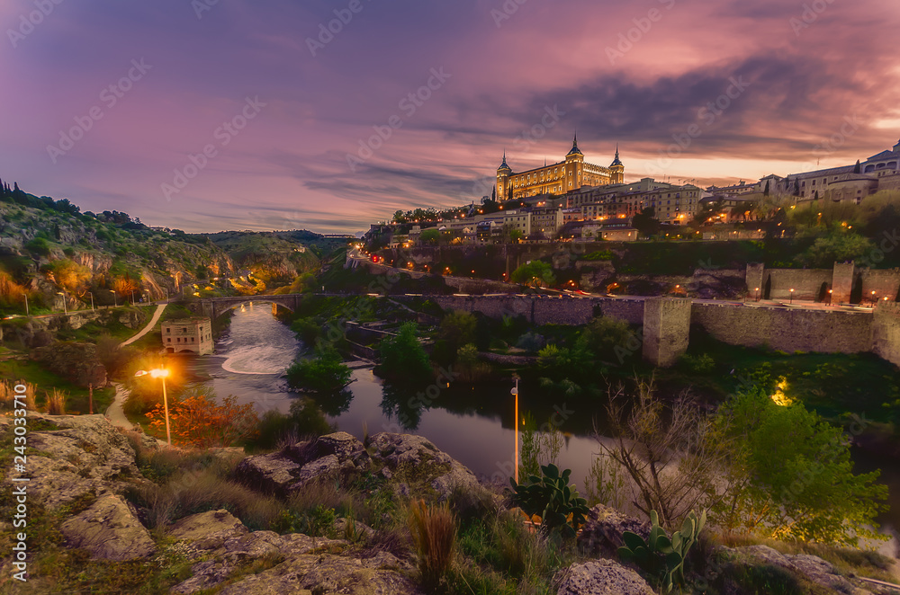 Toledo seen from the other side of the Tagus River at sunset with the Alcázar de Toledo illuminated