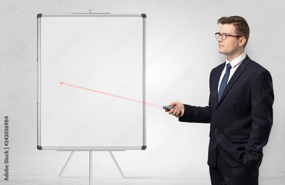 Young businessman with laser pointer and copyspace white blackboard Young businessman with laser pointer and copyspace white blackboard