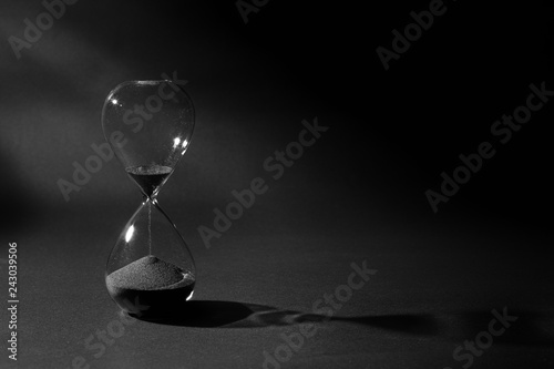 Hourglass On Black Background, Time Passing Concept, Black Sand Flowing Down From Upper Bulb To Lower Bulb Till Deadline
