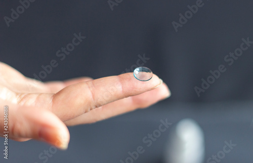 Woman hand holding eye lense on her finger