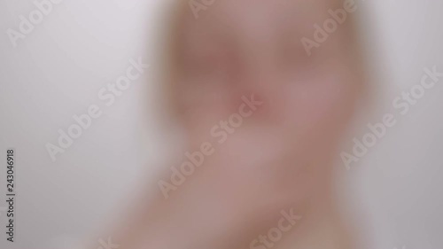 Woman shows a tablet while holding it with her fingers, then swallows it and drinks it with water