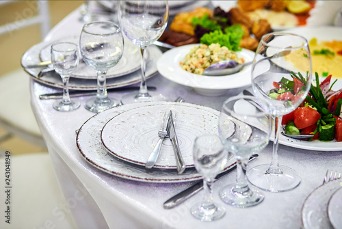 Elegant table setting in white beige tones ready for the arrival of guests. Beautiful dishes in restaurant interior