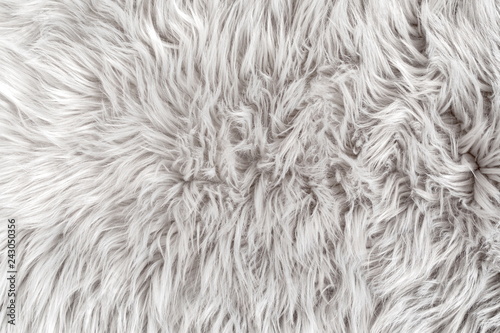 White fur for background or texture. Fuzzy white fur plaid. Shaggy blanket background. Fluffy fake textile fur. Flat lay, top view, copy space 