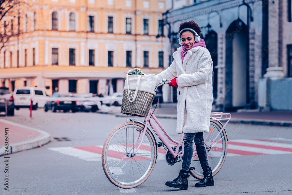 Positive delighted girl walking with pleasure alone