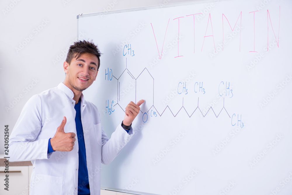 Young chemist standing in front of the whiteboard Young chemist standing in front of the whiteboard