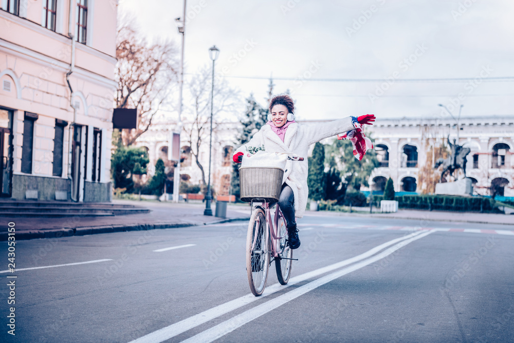 Positive delighted brunette girl riding her bicycle