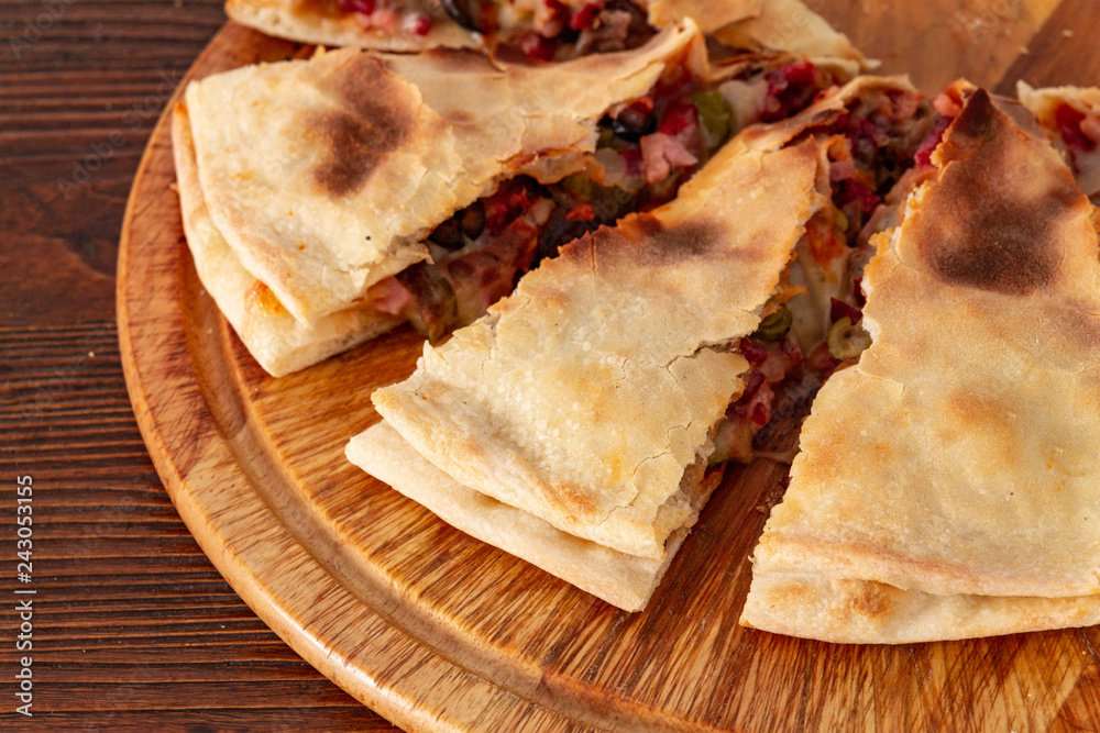 Pizza calzone on the textured table, for the restaurant menu, cafe, advertising. Pizza calzone on the textured table, for the restaurant menu, cafe, advertising.