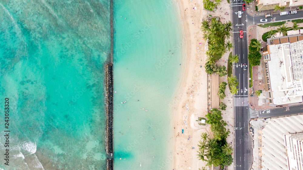 Stunning aerial drone view of Kuhio Beach, part of Waikiki Beach in Honolulu on the island of Oahu, Hawaii. The beach is protected from the ocean through a concrete wall, making it an ocean pool. Stunning aerial drone view of Kuhio Beach, part of Waikiki Beach in Honolulu on the island of Oahu, Hawaii. The beach is protected from the ocean through a concrete wall, making it an ocean pool.