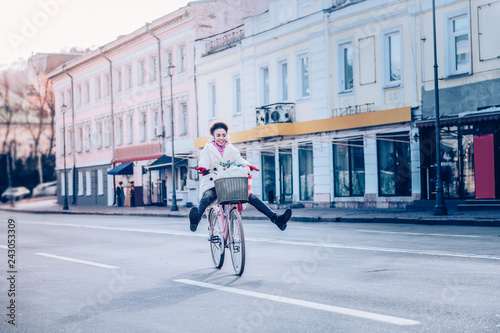 Joyful female person riding bicycle with pleasure