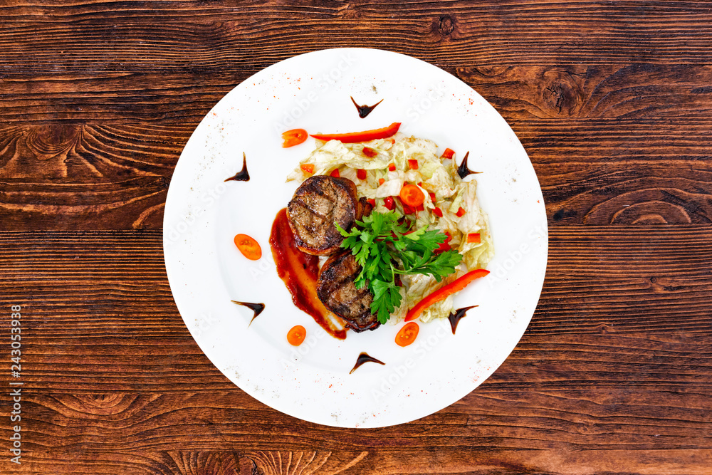 Juicy beefsteak minion from medium rare beef with a sauce on a white plate Juicy beefsteak minion from medium rare beef with a sauce on a white plate