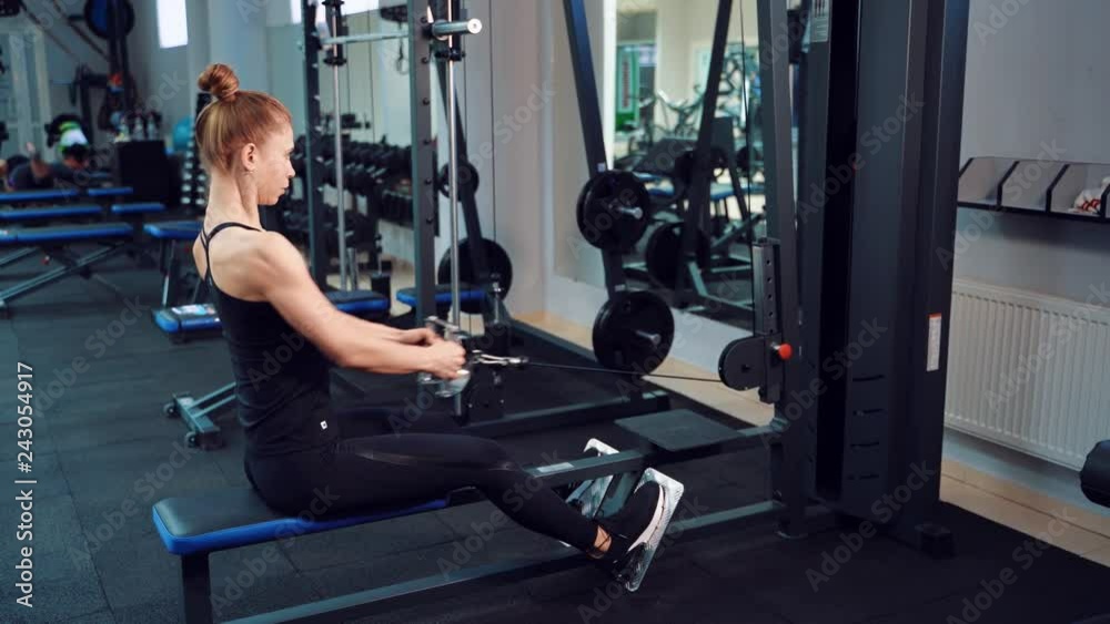 Sporty woman is doing an exercise to strengthen the shoulder girdle, muscles of the back, arms and legs in a fitness club. Healthy lifestyle. Sporty woman is doing an exercise to strengthen the shoulder girdle, muscles of the back, arms and legs in a fitness club. Healthy lifestyle.