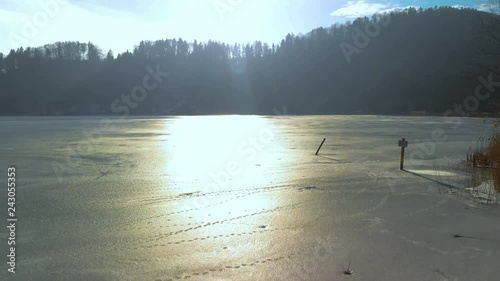 Aerial view of a frozen little Lake in Switzerland at a sunny winter Day