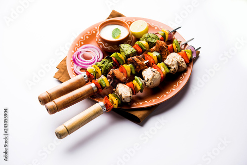 Chicken Hariyali kakab or Malai malai kebab served with skewers and yogurt dip in a plate. selective focus photo